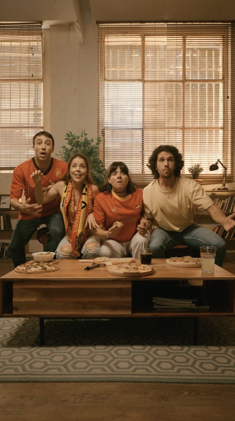 Amigos viendo el partido con pizza